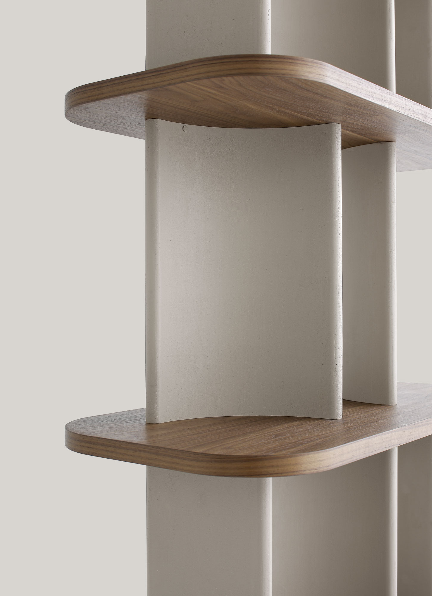 Versatile bookcase with a blend of concrete effect Marmorino and walnut veneer.